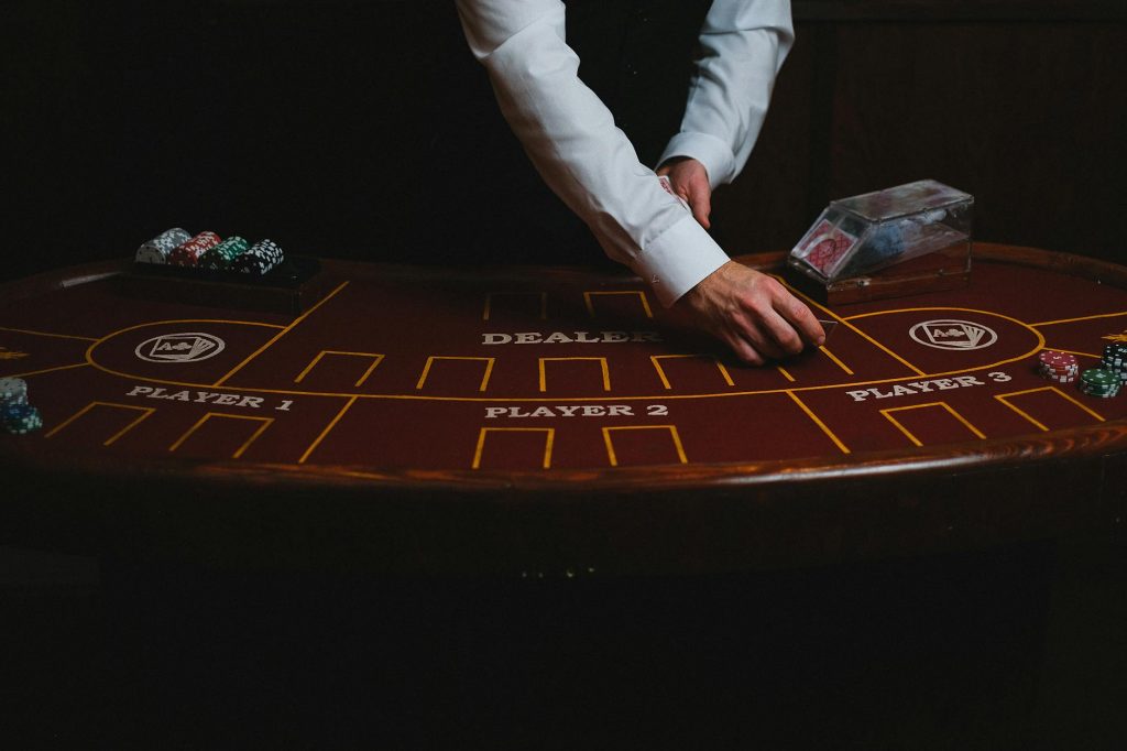 Dealer chia bài tại bàn casino trực tiếp trong studio hiện đại